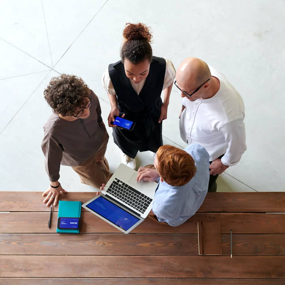 About Avada Business Vista cenital de un grupo de gente dentro de un despacho de abogados en medio de una reunión de servicios de asesoría y abogacía.